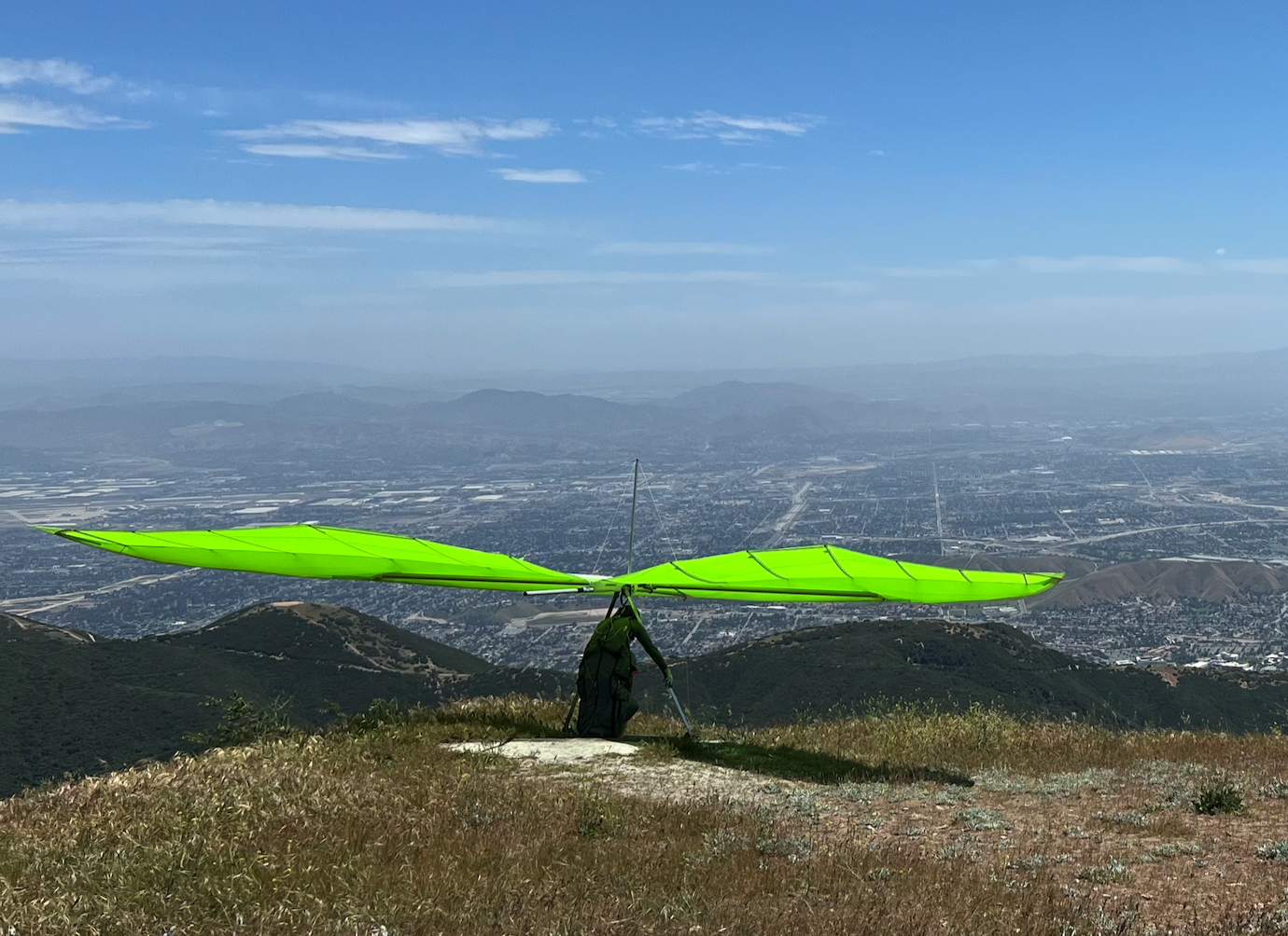 Hang glider soaring over mountain ridge